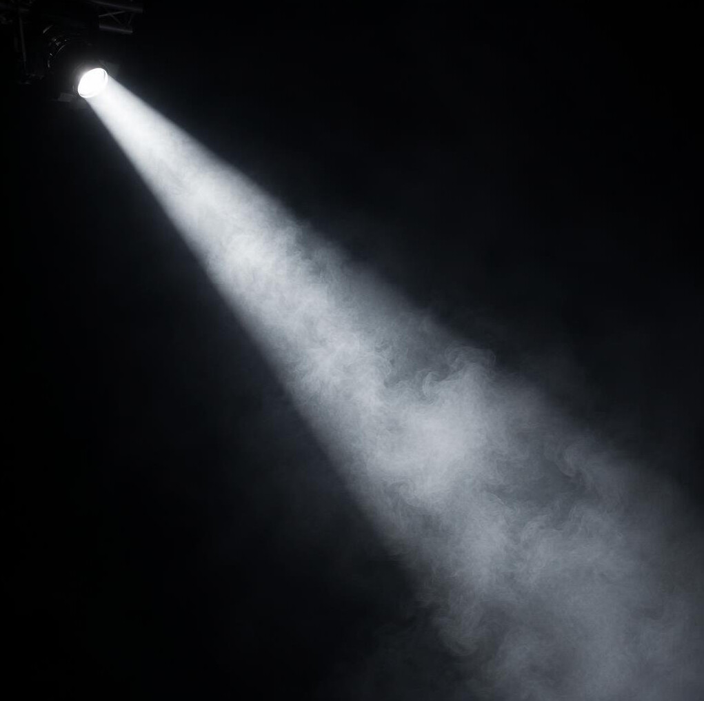 Single spotlight beam cutting through stage haze