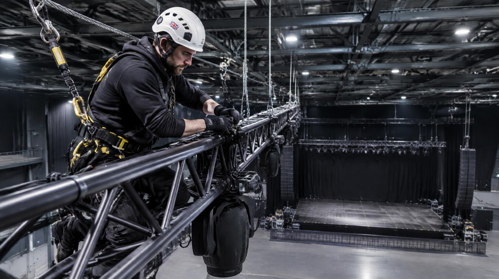 Rigger installing lighting truss above a stage